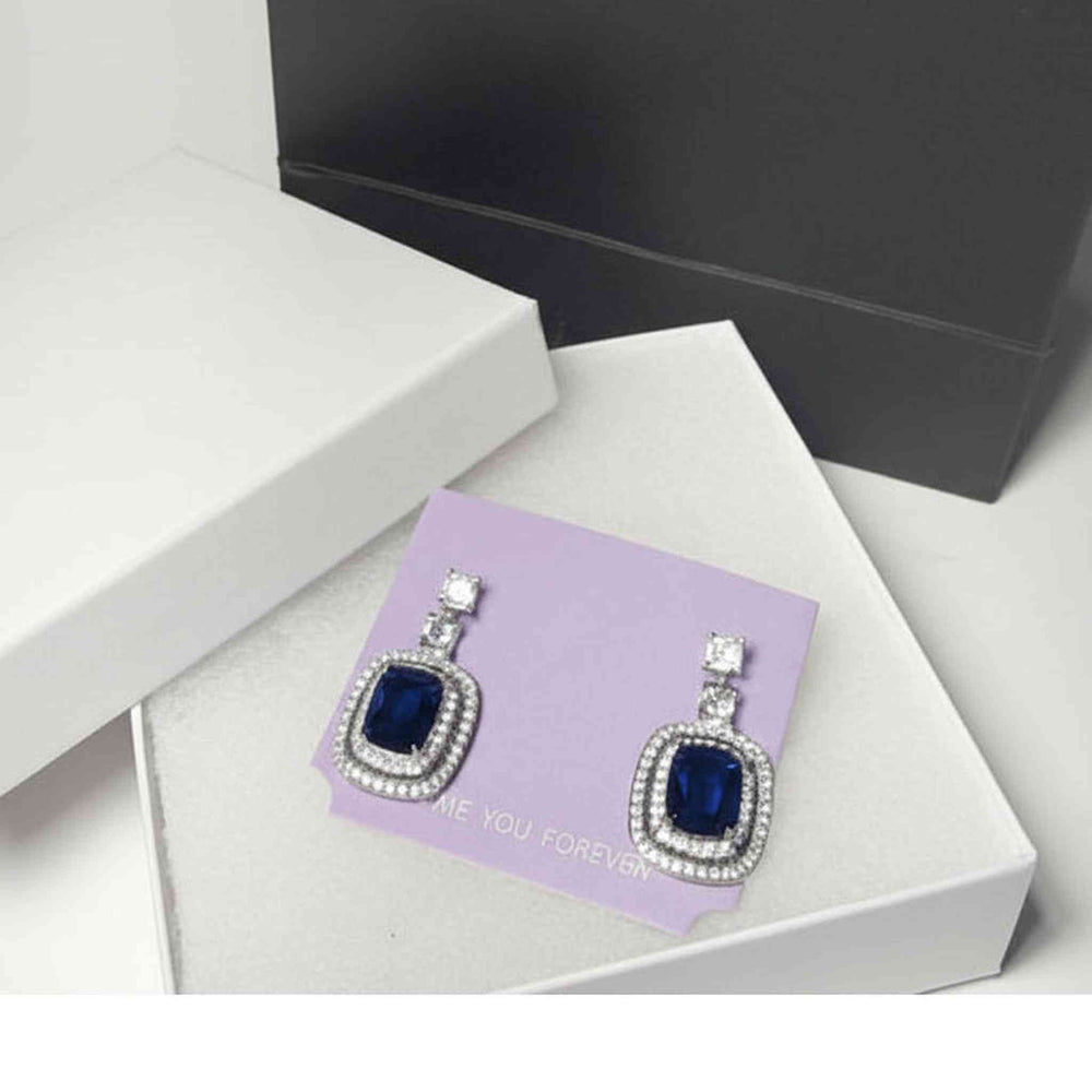 close-up of blue stone drop earrings showing faceted gemstone details