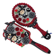 detail of gothic hand mirrors with red flat back rhinestones, black roses and monster figures