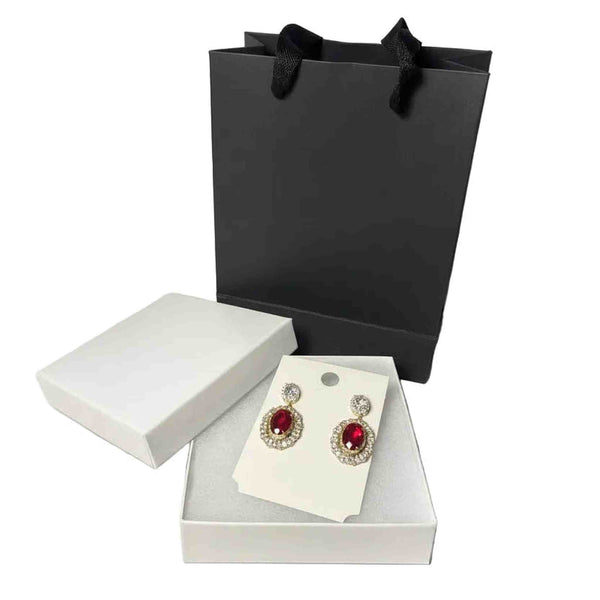 elegant gold-tone earrings with ruby red gemstones, gift box and black paper bag