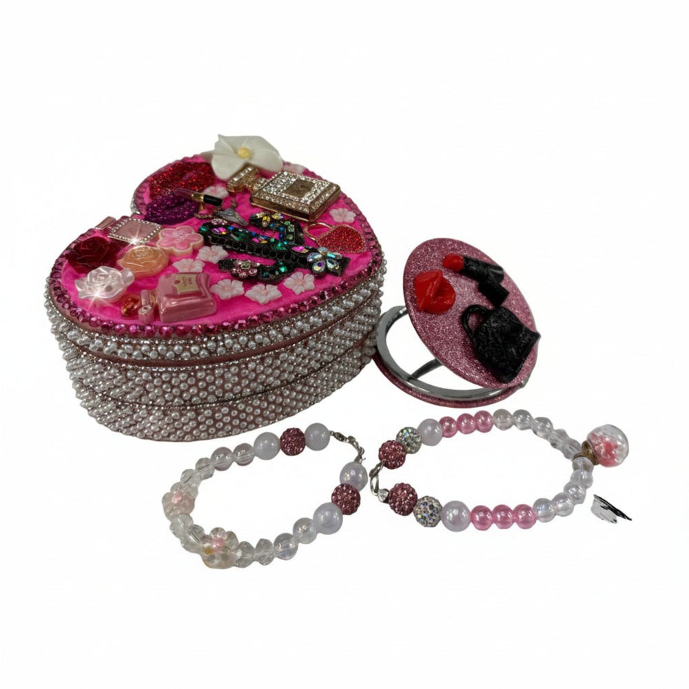 heart shaped jewelry box decorated with roses and rhinestones next to two handmade beaded bracelets