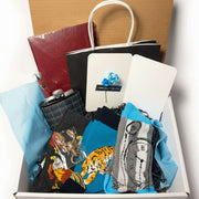 Hand-curated luxury men's gift box featuring a plaid flask, executive notebook, and handcrafted exotic woman bust keychain from Majestic Boutique.