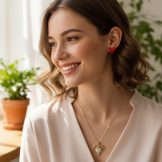 Model wearing a handmade jewelry set featuring a gold-tone heart pendant necklace and matching red crystal earrings.