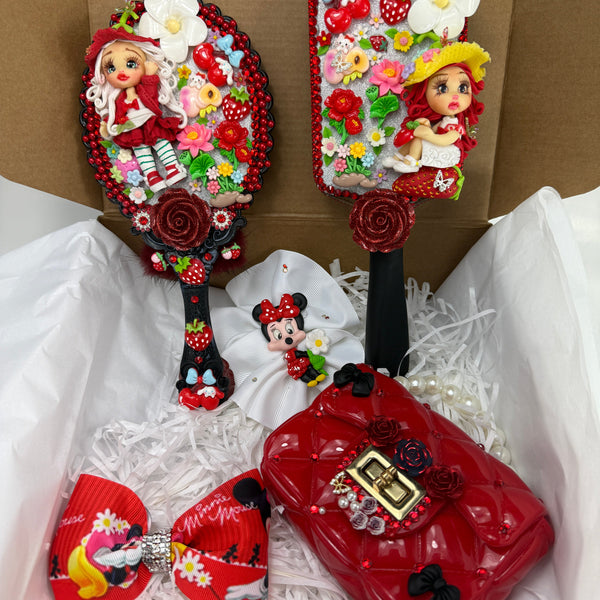 open gift box with red strawberry coquette vanity set featuring decorated hair brush hand mirror small purse and bows