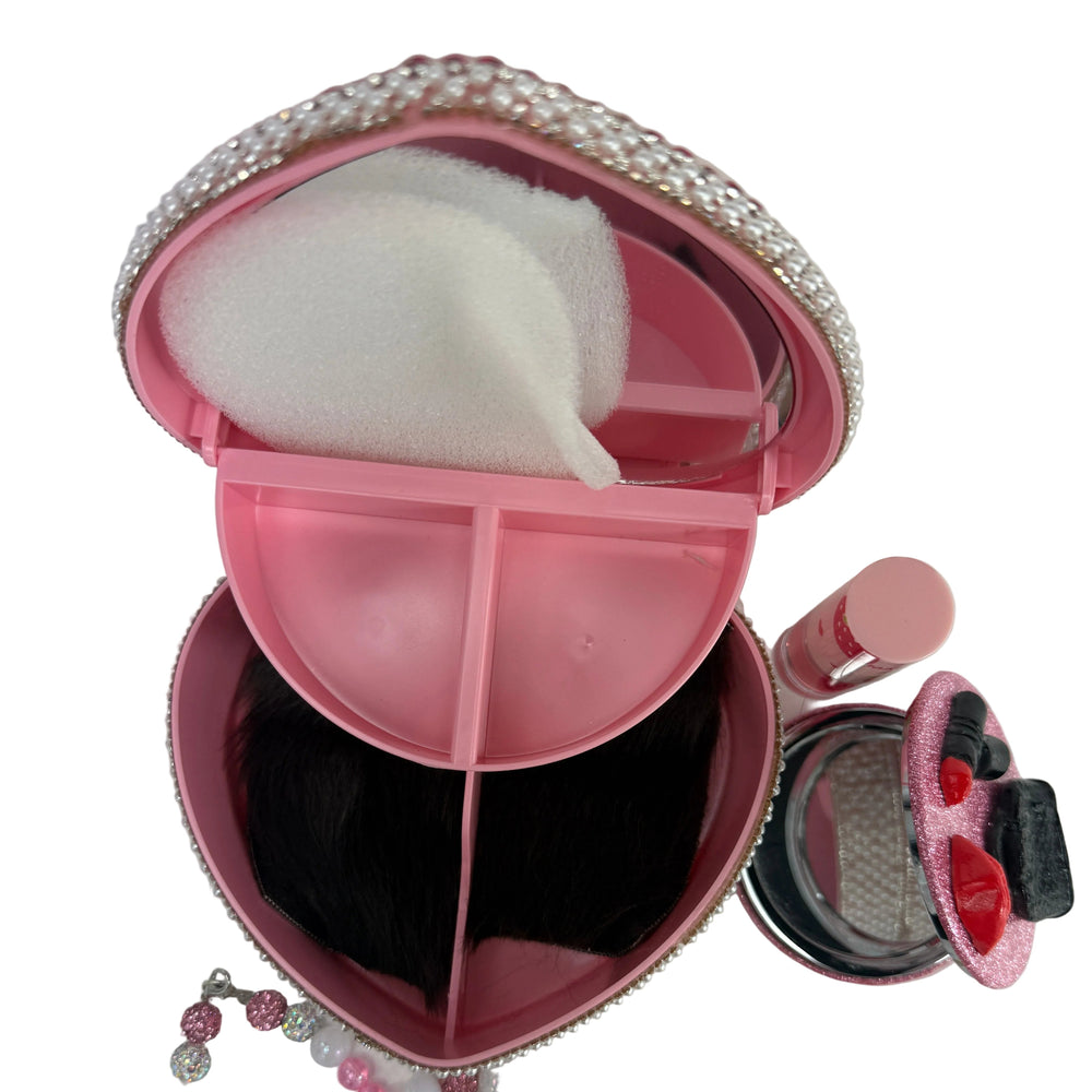 open pink jewelry box from side view showing interior space with a sparkly compact mirror and lip gloss