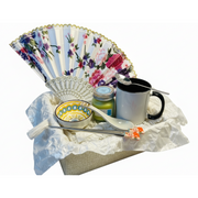 Angled view of oriental tea gift set with floral folding fan and scented candle
