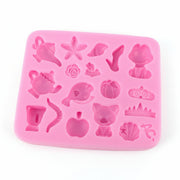pink silicone mold for jewelry making with multiple small cavities including nature-inspired motifs like pumpkins and sea-themed shapes