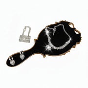 rhinestone mini purse charm, crystal ankle bracelet, and sparkling earrings displayed on a gold mirror