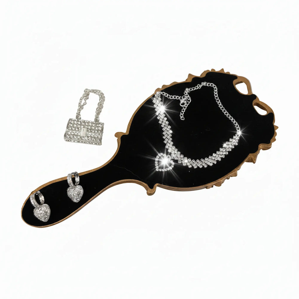 rhinestone mini purse charm, crystal ankle bracelet, and sparkling earrings displayed on a gold mirror