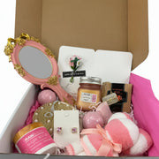 self-care gift basket with raw sugar scrub, bamboo body scrubber, aromatherapy candle, and teddy bear towel