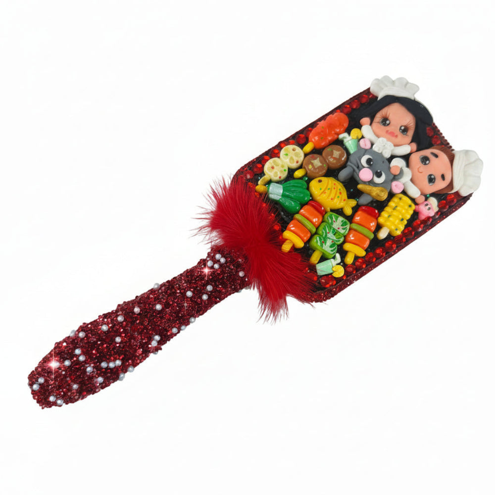 side view of a custom hair brush with clay chefs riding a mouse surrounded by tiny food charms and red glitter