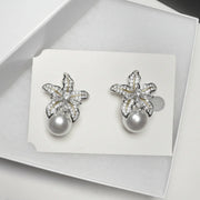 silver floral rhinestone earrings in white jewelry box