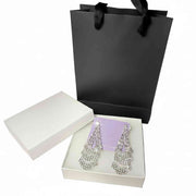 silver rhinestone dangle earrings displayed with premium white gift box and black paper bag