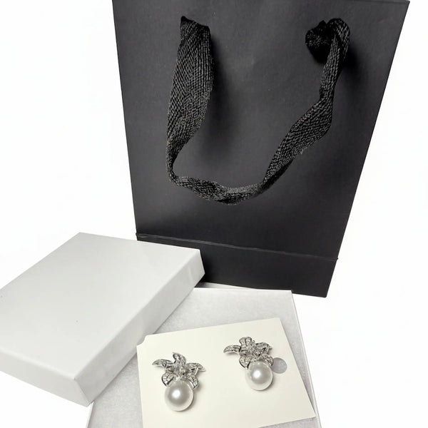 sparkly floral earrings with pearls and black gift bag