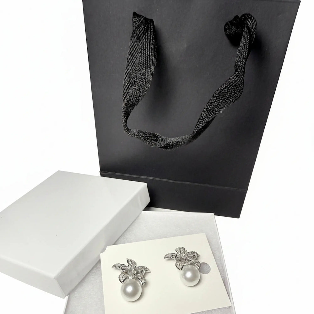 sparkly floral earrings with pearls and black gift bag