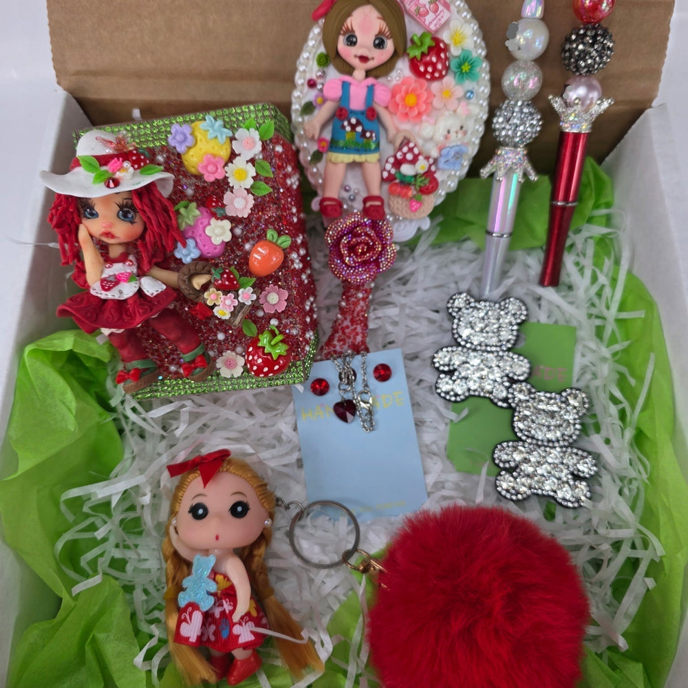 strawberry themed gift box featuring a clay doll pencil holder, hair clips, keychain, and stationery items