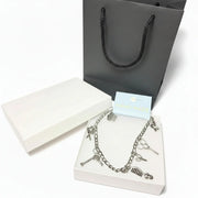 stylist charm anklet with silver-tone pendants in a luxury white gift box.